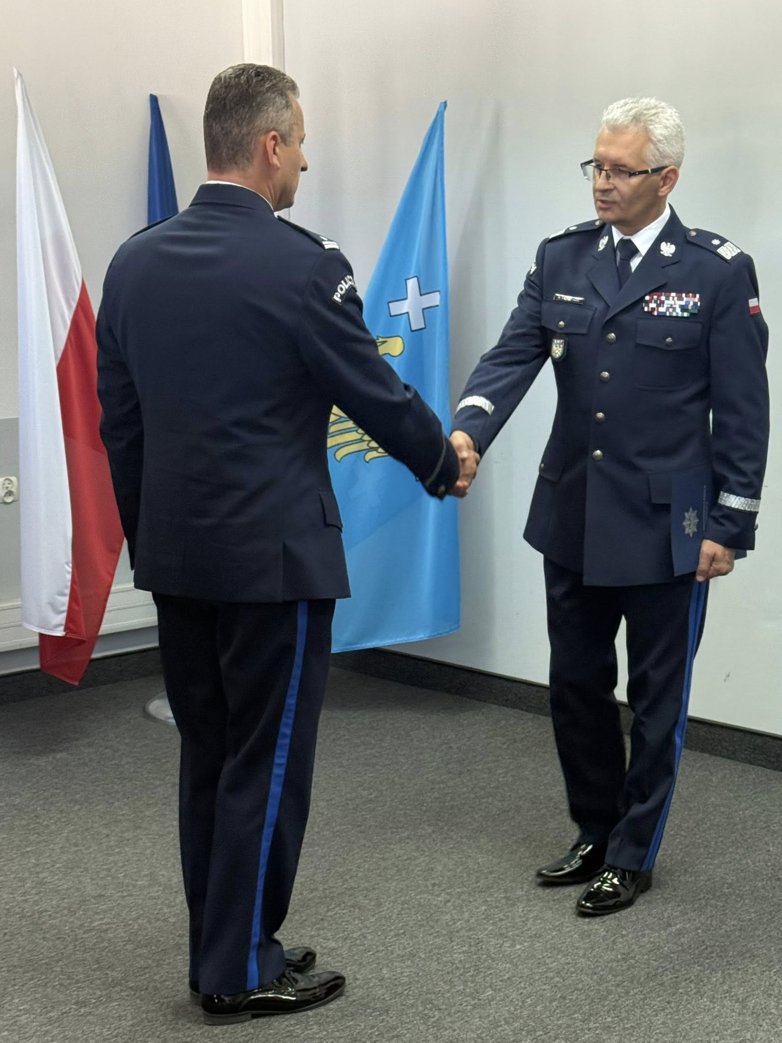 Policjanci w mundurach galowych składają sobie wzajemnie gratulacje