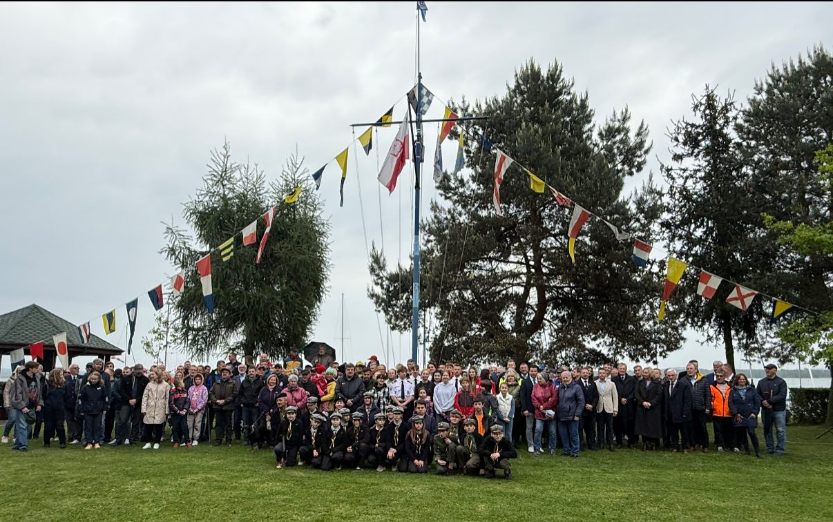 Duża grupa osób pozująca na łące do zdjęcia 