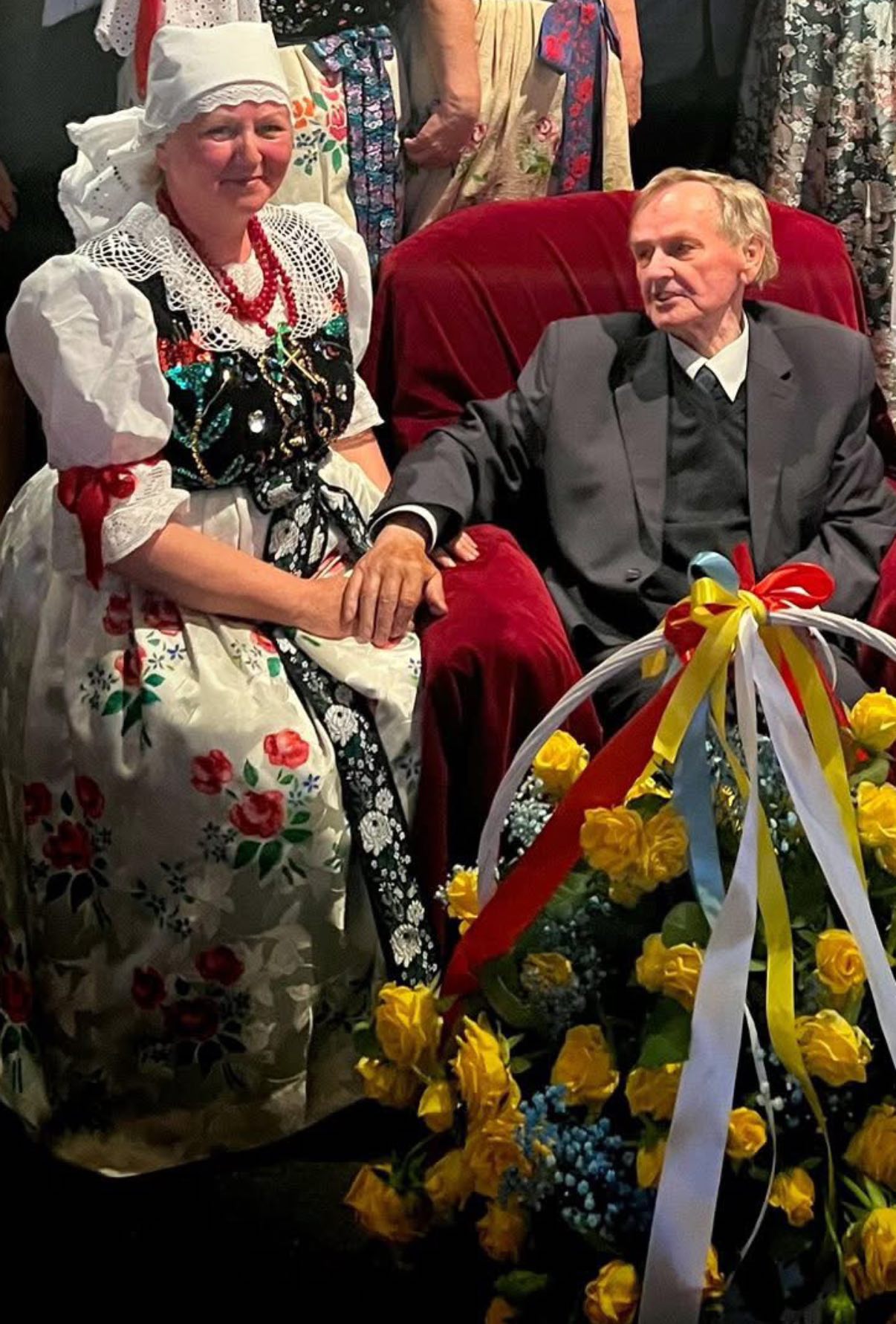 Mężczyzna i kobieta w stroju ludowym z bukietem kwiatów 