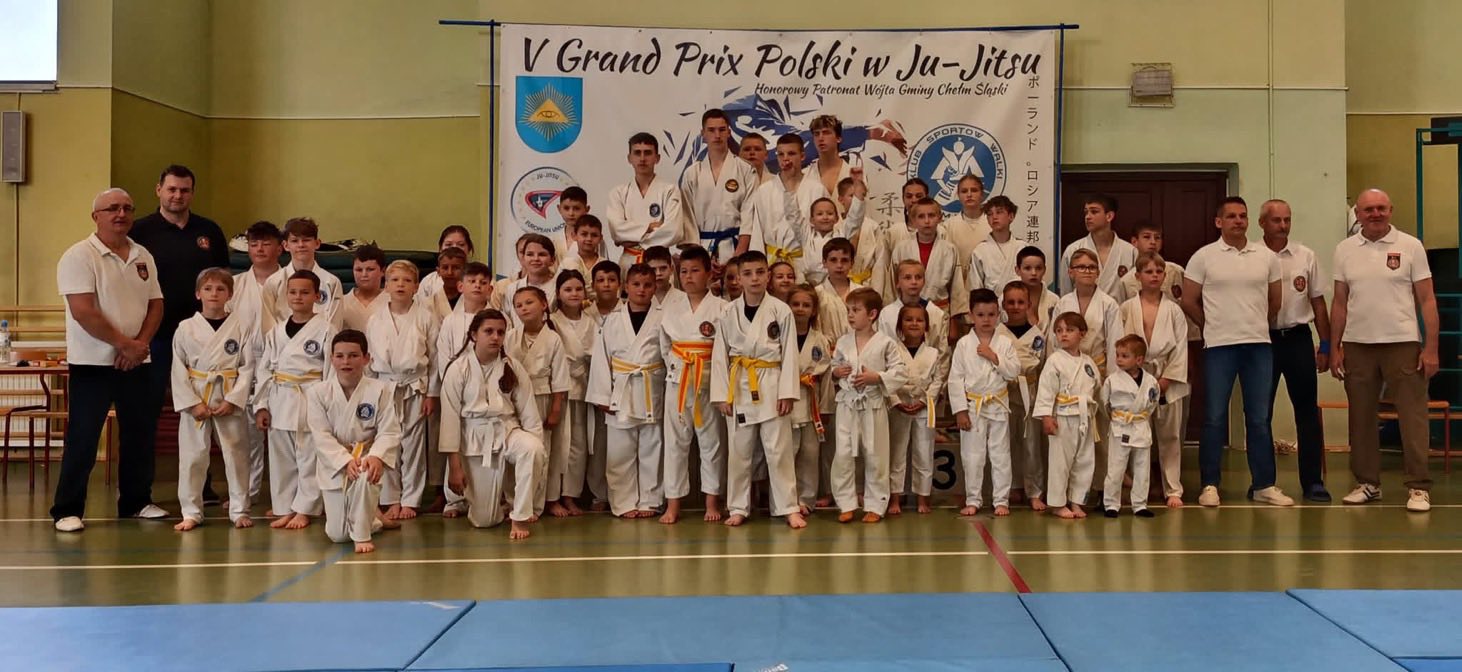 Osoby pozujące w strojach ju - jitsu po zawodach