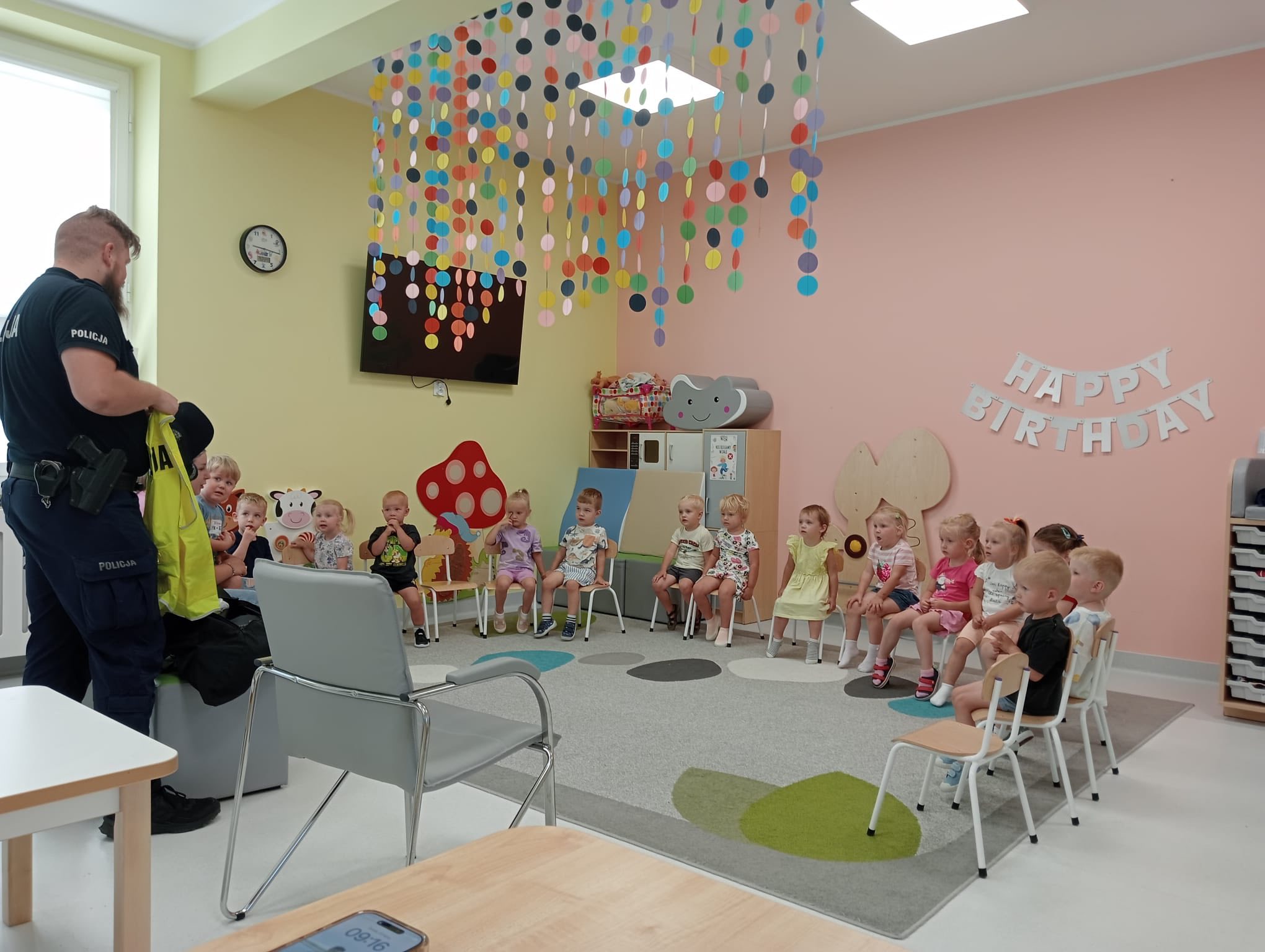 Dzieci siedzace w sali zajęć . Dzieci odwiedził policjant.