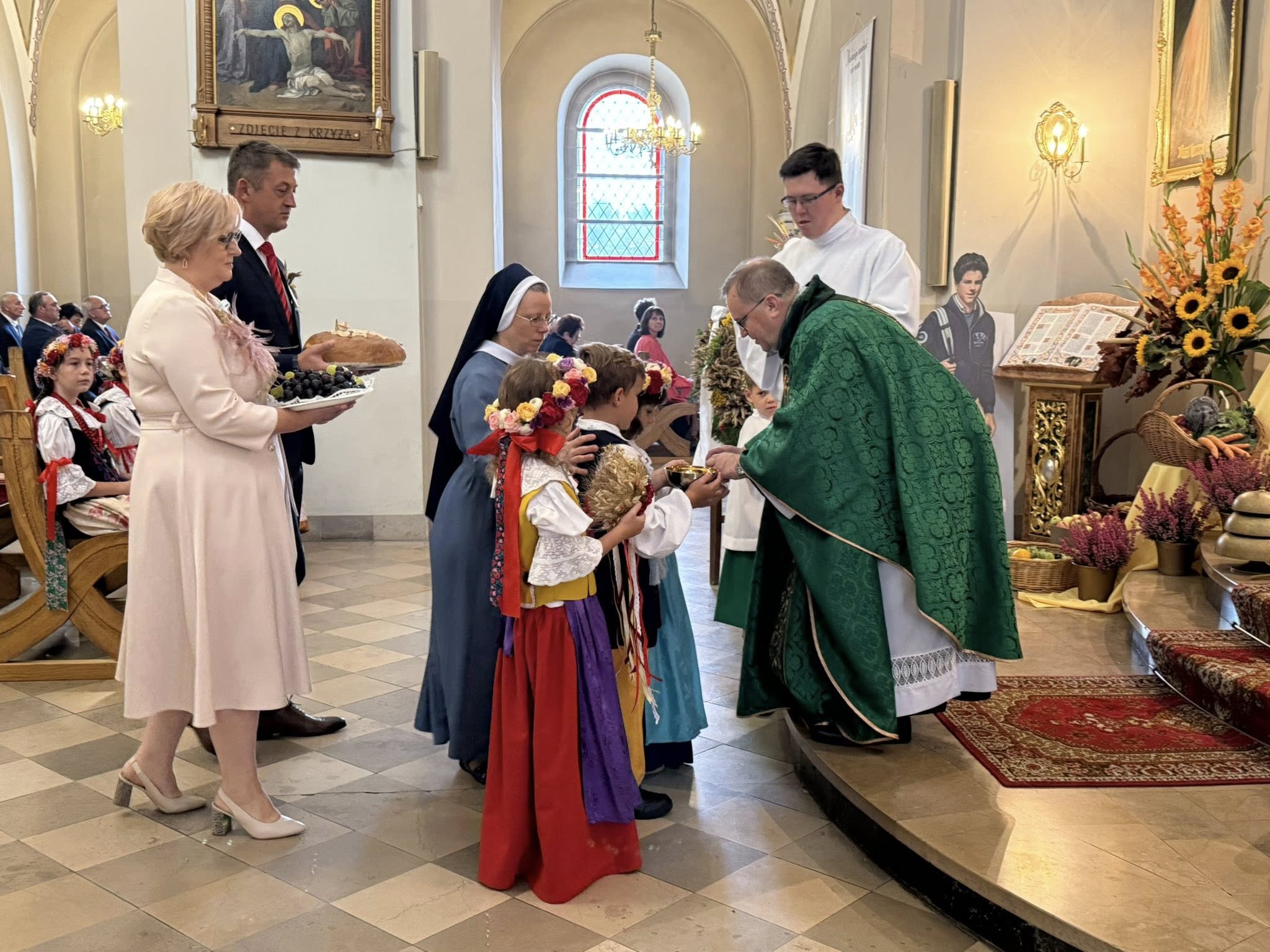 w kościele proboszcz odbiera dary od dzieci starostów dożynkowych 