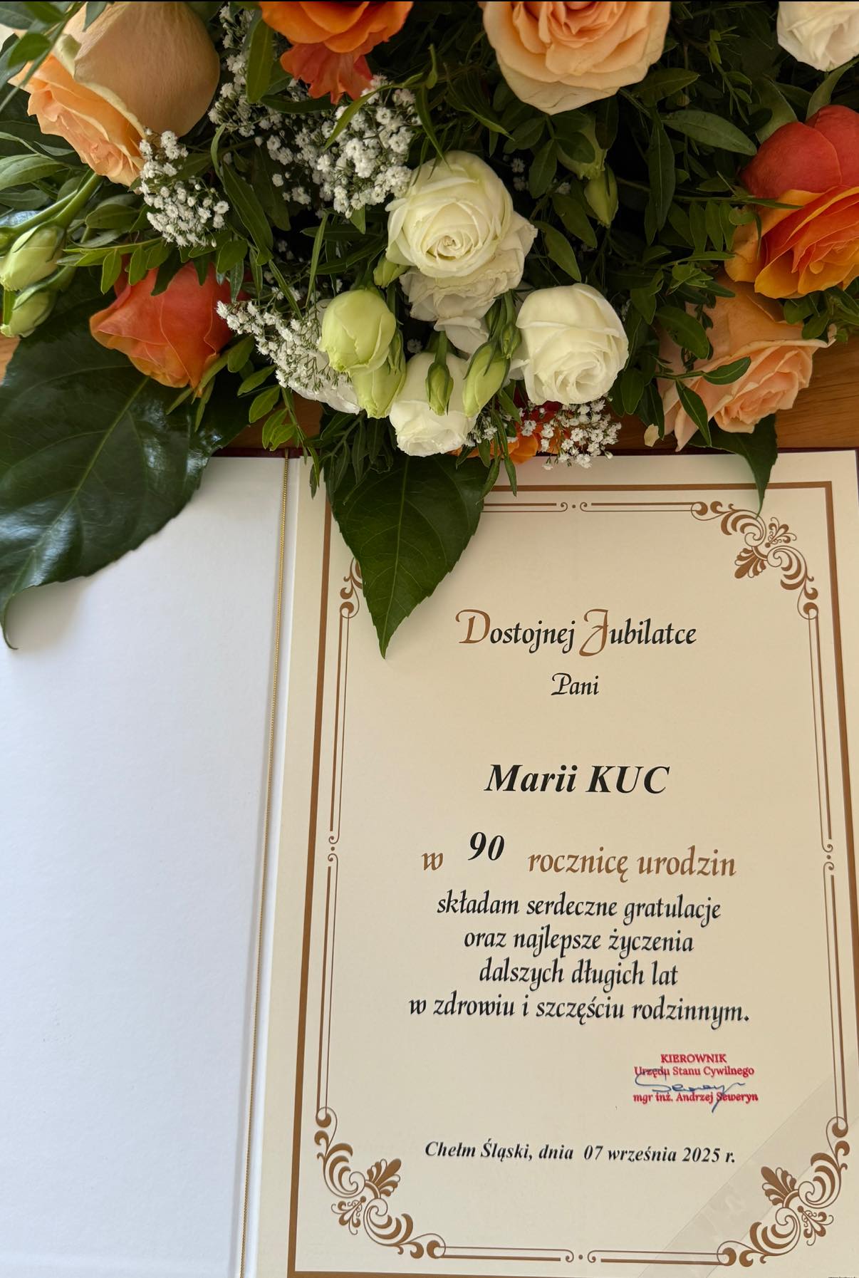 Kwiaty i dyplom pamiątkowy dla jubilatki 