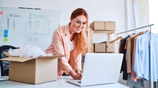kobieta przy komputerze i kartonach w pomieszczeniu
