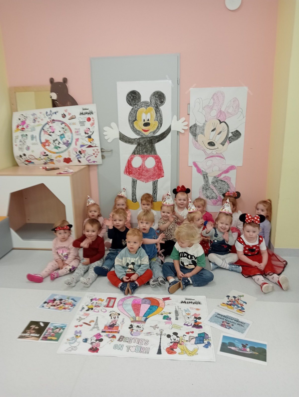 Dzieci siedzące na podłodze w pomieszczeniu - pozujące do zdjęcia. 