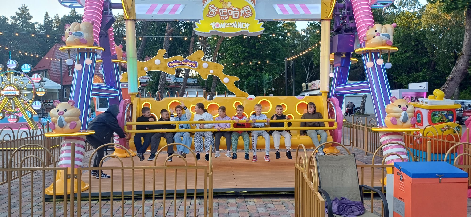 Dzieci pozujące do zdjęia w wesołym miasteczku 